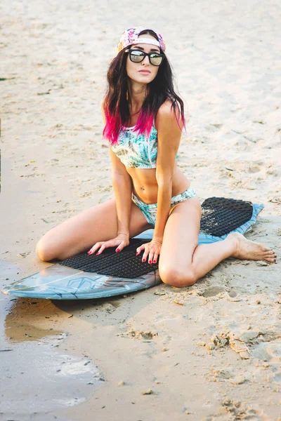Szörfös lány a strandon naplementekor — Stock Fotó