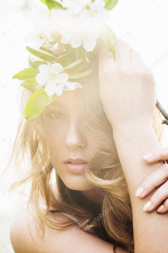Portrait of beautiful romantic lady in apple trees blossoms