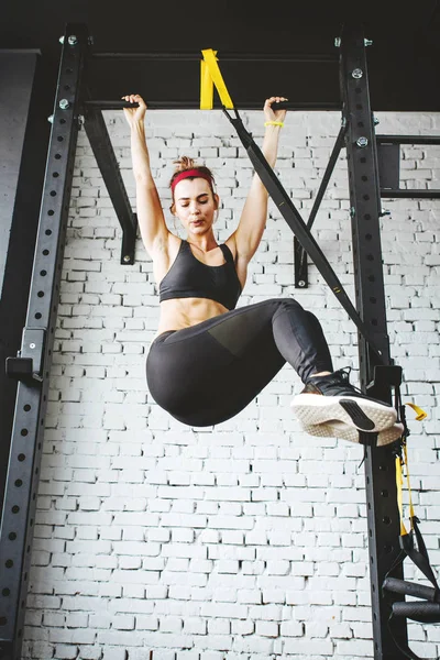 Młody fitness kobieta robi pull up w siłowni — Zdjęcie stockowe