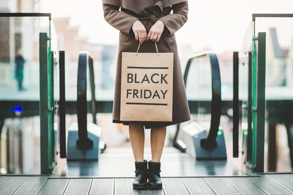 Женщина держит черный пятничный пакет бумаги — стоковое фото