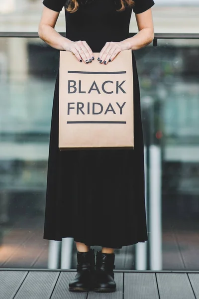Женщина держит черный пятничный пакет бумаги — стоковое фото