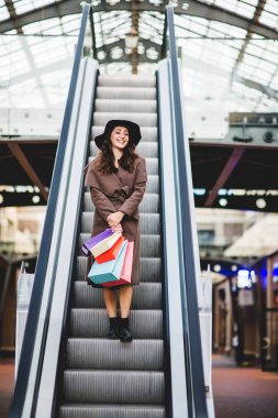 alışveriş torbaları ile genç gülümseyen kadın