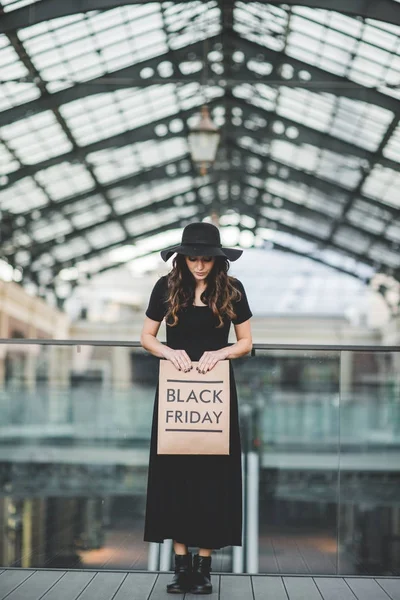 Woman holding Black Friday paper bag — Stock Photo, Image