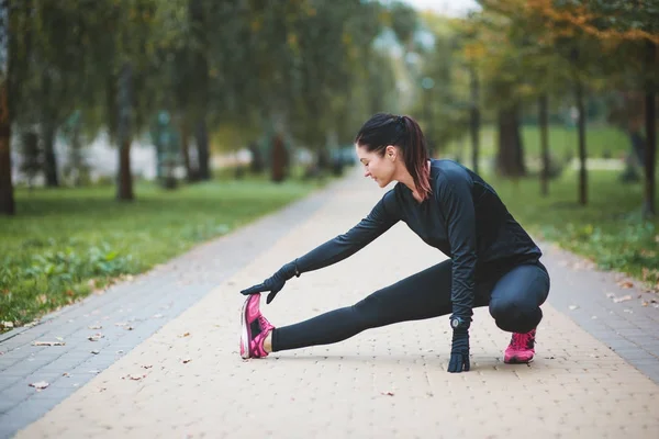 Young woman doing some warm-up exercises before running. — Stock Photo, Image