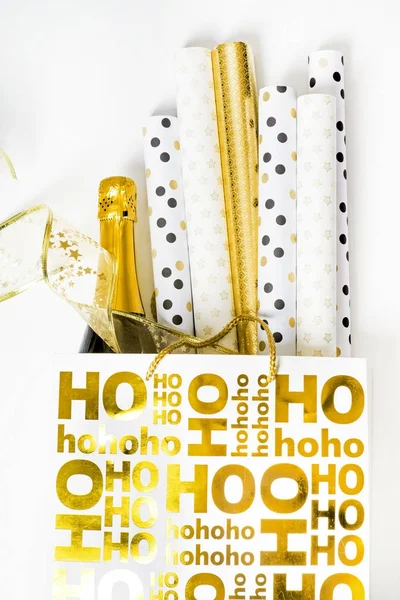 Shopping bag with wrapping paper and bottle of champagne — Stock Photo, Image