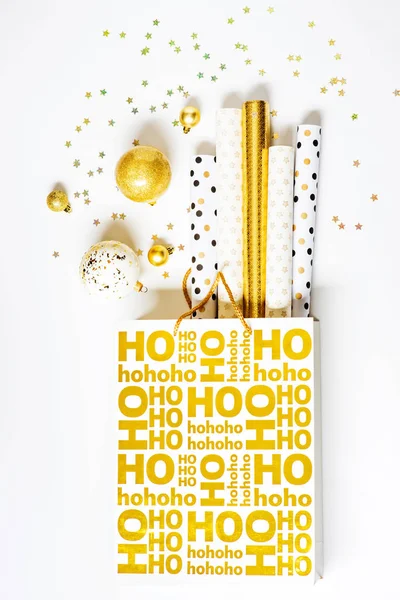 Golden christmas shopping bag with wrapping paper — Stock Photo, Image