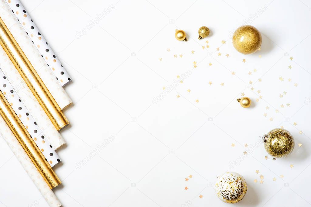 Rolls of gold and white wrapping paper for gifts on white background