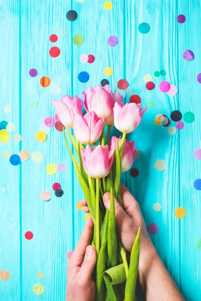Bouquet of pink tulip flowers in man hands on blue wooden background — Stock Photo, Image