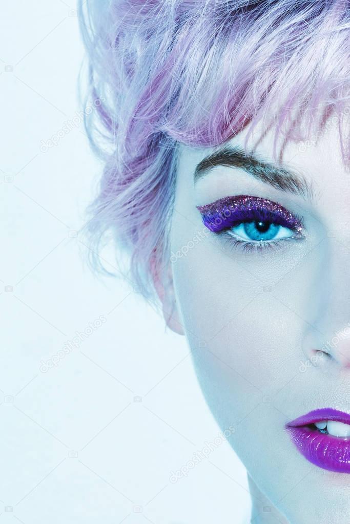Croped image of beautiful woman face with ultra violet make-up