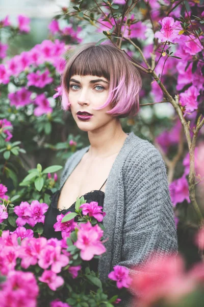 Hermosa mujer con pelo rosa en el jardín floreciente de primavera —  Fotos de Stock