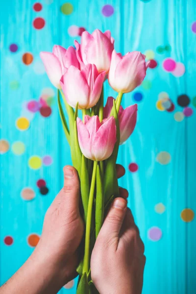 Bouquet of pink tulip flowers in man hands on blue wooden background — Stock Photo, Image