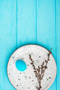 Ahşap arka plan üzerinde bir plaka üzerinde mavi Paskalya yortusu yumurta