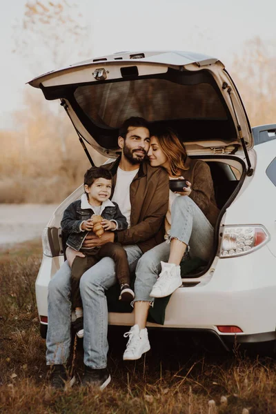 Joyeux famille assis dans un coffre de voiture . — Photo