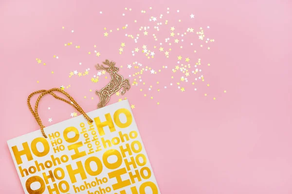 Christmas paper bag with golden reindeer and stars on pink background. — Stock Photo, Image