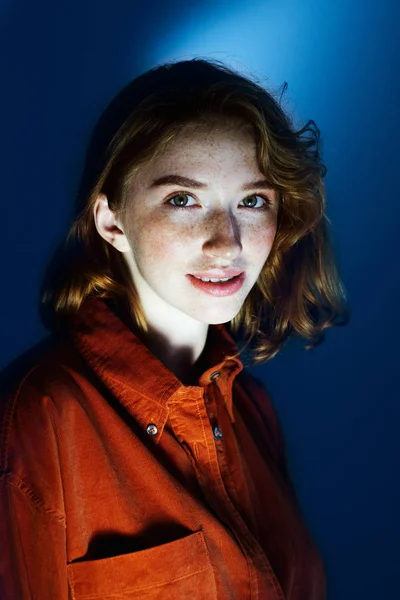 Klasik mavi arka planda çilli kızıl saçlı kızın portresi.. — Stok fotoğraf