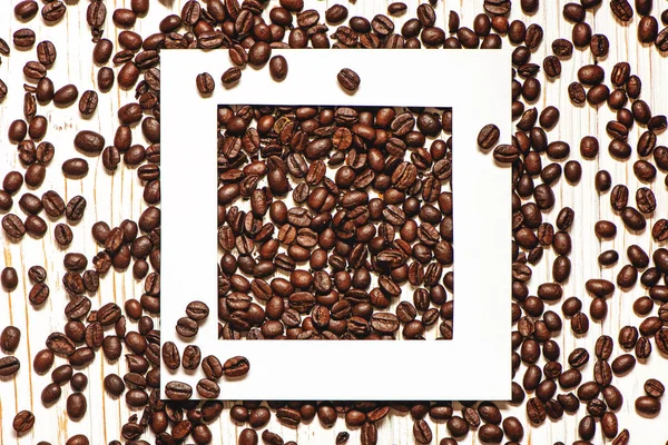 Kreativ layout med vit ram och rostade kaffebönor. — Stockfoto