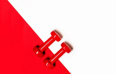 Kırmızı ve beyaz arka plan üzerinde kırmızı dambılileli düz döşeme kompozisyonu.