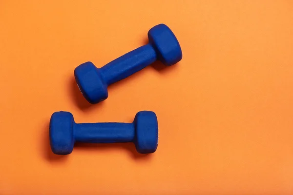 Par de pesas azules Aisladas sobre fondo naranja . —  Fotos de Stock