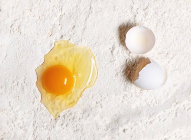 Beyaz un arka planında kırılmış yumurta..