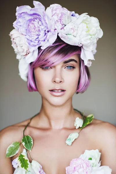 Gri arka planda şakayık çiçeklerinden yapılmış çelengi olan güzel bir kadının portresi.. — Stok fotoğraf