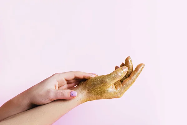 Perfecte manicure met trendy nagelkunst en hand met gouden glitter op roze achtergrond. — Stockfoto