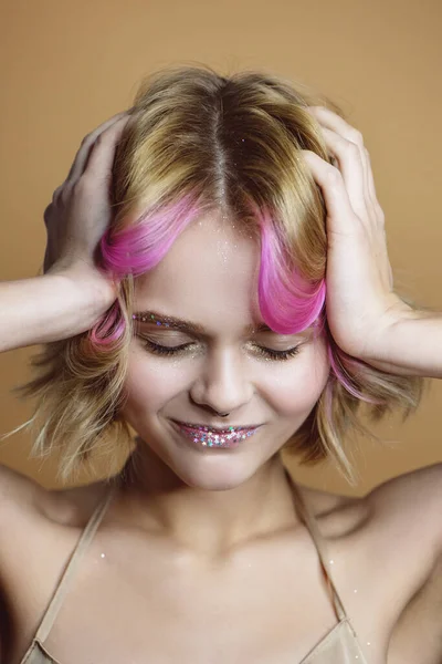 Hermosa joven con hebras rosadas cogidas de la mano en la cabeza . —  Fotos de Stock