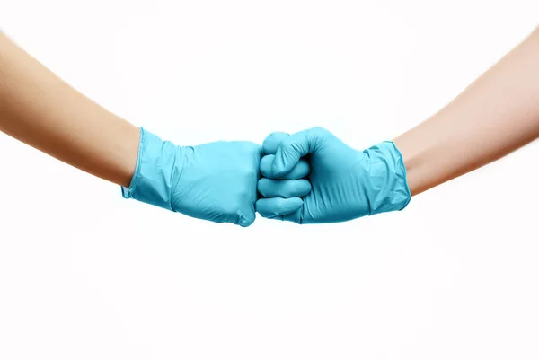 A barátok kezei orvosi kesztyűben ökölpacsival üdvözlik egymást.. — Stock Fotó