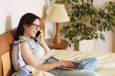 Yatakta çalışan güzel genç bir kadın..