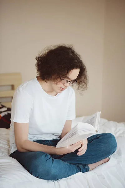 Nastoletni chłopiec czyta książkę. — Zdjęcie stockowe