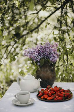 Bir fincan çay ve leylaklı taze çilek..