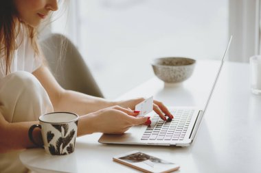 İnternetten alışveriş yaparken kart bilgilerini giriş yapan kadın.