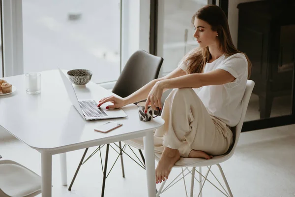 Frau benutzt Laptop in der Küche zu Hause. — Stockfoto