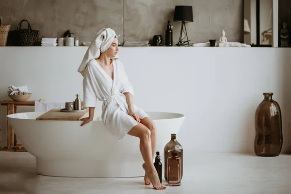 Frau sitzt auf der Badewanne. — Stockfoto