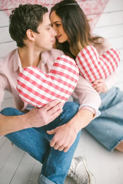 Kalp şeklindeki yastıklar aşk hikayesi için poz ile genç Çift — Stok fotoğraf