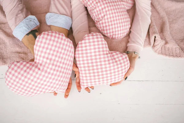 Männliche und weibliche Hände auf dem Boden mit Kissen im Studio — Stockfoto