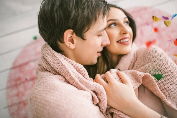 Joven pareja en el amor abrazando bajo confeti en decorado studi — Foto de Stock