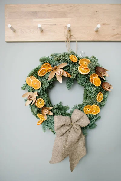Green Christmas tree wreath with oranges decoration at home