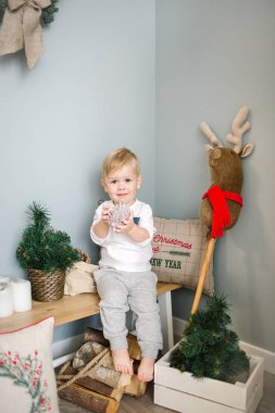 Genç çocuk Noel dekore edilmiş oda oyuncak geyik ile oynarken