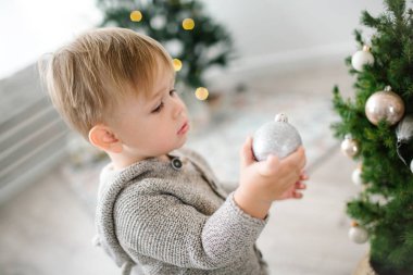 Küçük sevimli sarışın bebek çocuk topları ile Noel ağacı süsleme