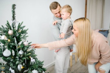 Şirin bebek çocuk ebeveynleri ile Noel ağacı süsleme