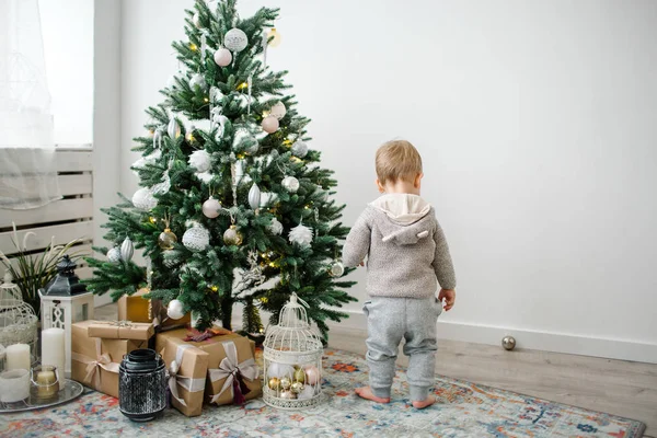 Petit garçon à la recherche de cadeaux à l'arbre de Noël — Photo