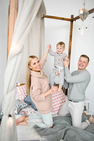 Feliz joven padres con bebé niño en Navidad habitación decorada —  Fotos de Stock