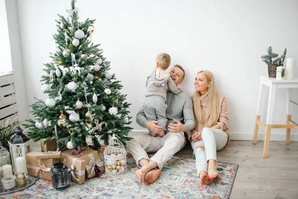 Cute baby boy decorating christmas tree with parents — Stock Photo, Image