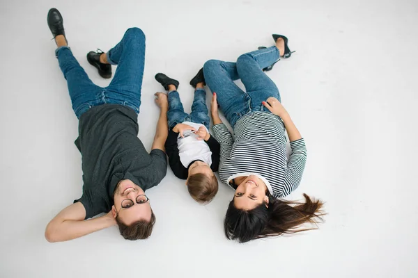 Hipster father, mother lying with baby boy on white background — Stock Photo, Image