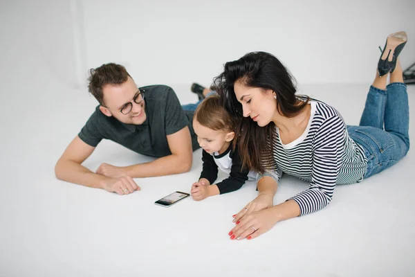 Hipster padre, madre acostada con el niño sobre fondo blanco —  Fotos de Stock