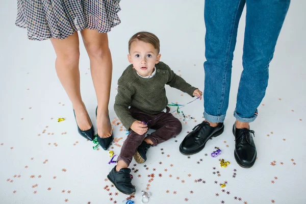 Pareja joven con hijo celebrando con confeti sobre fondo blanco —  Fotos de Stock