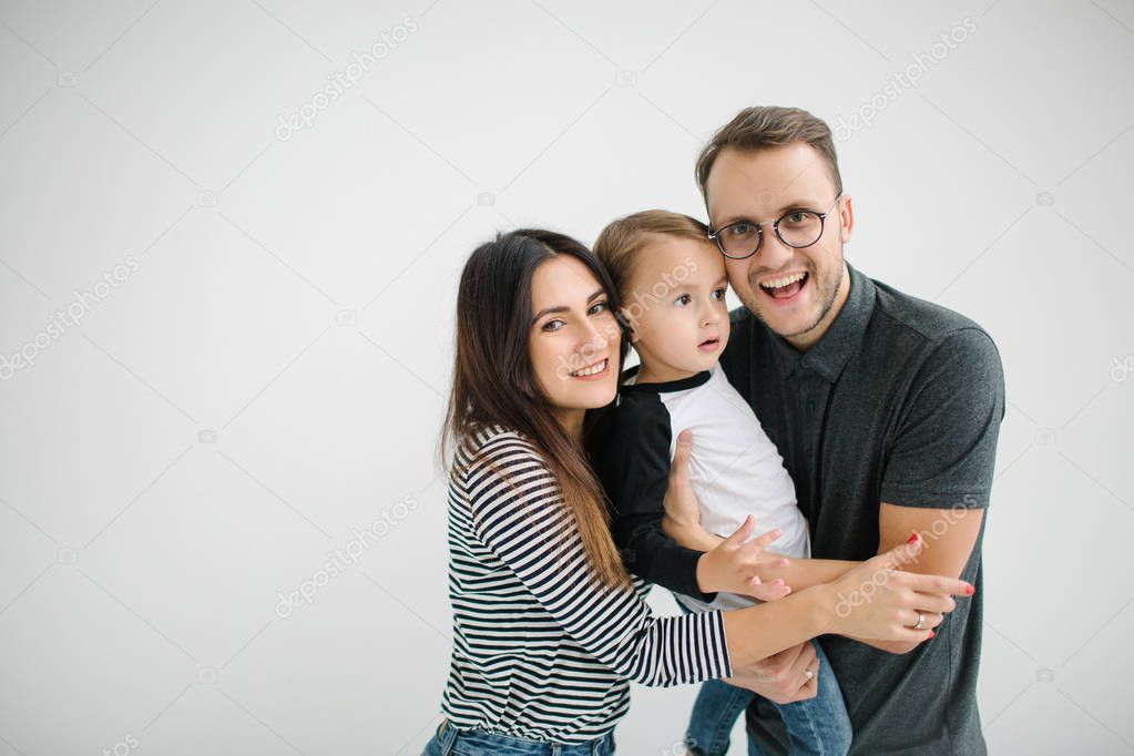 Hipster father, mother holding baby boy over white isolated background