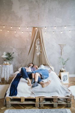 Genç hippi çift el yapımı yatakta dreamcatche ile eğleniyor