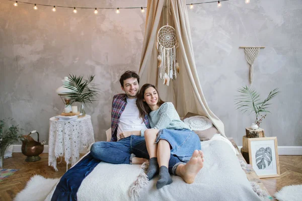 Young hipster couple having fun on handmade bed with dreamcatche — Stock Photo, Image