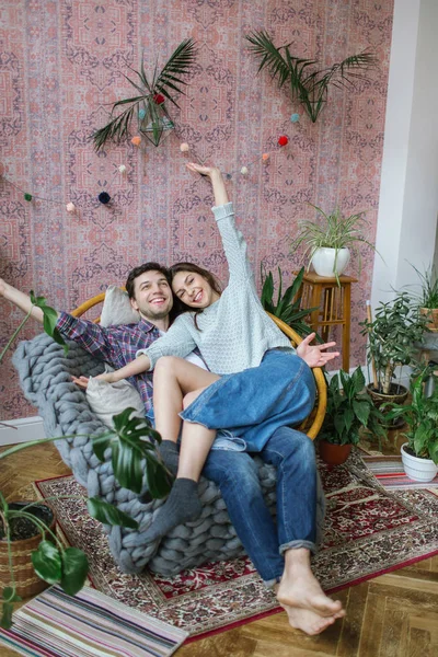 Young hipster couple having fun on old armchair in apartment — Stock Photo, Image